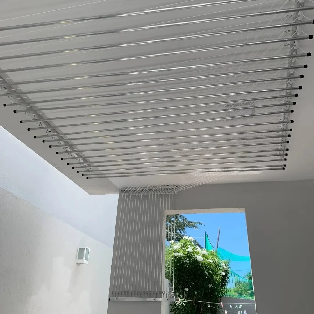 Varal de teto amplo instalado em área coberta com vista para o jardim
